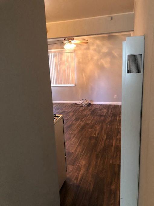 A room with a wooden floor and a white wall.
