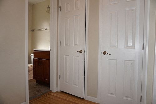 A white door is open to a room with a brown cabinet.