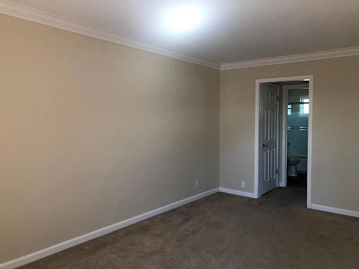 a empty living room with a door to a bathroom