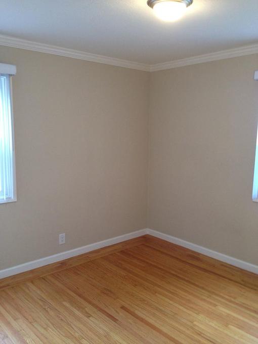 A room with wooden flooring and a window.