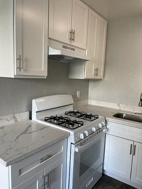 A white kitchen with a stove and cabinets.