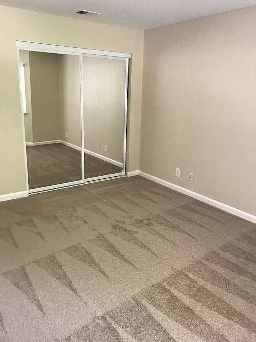 A room with a carpeted floor and a glass door.