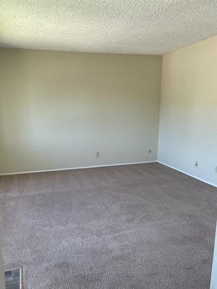 A room with a carpeted floor and a white wall.