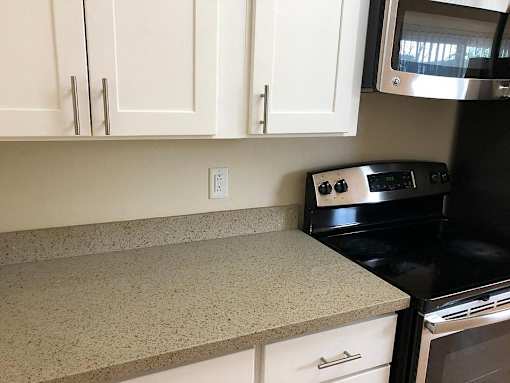 a kitchen with white cabinets and a black stove
