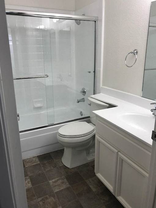 A white toilet in a bathroom with a glass shower door.