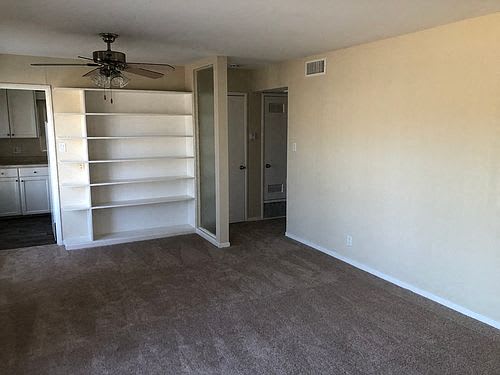 an empty room with a closet and a ceiling fan