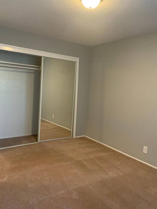 A room with a carpeted floor and a sliding glass door.