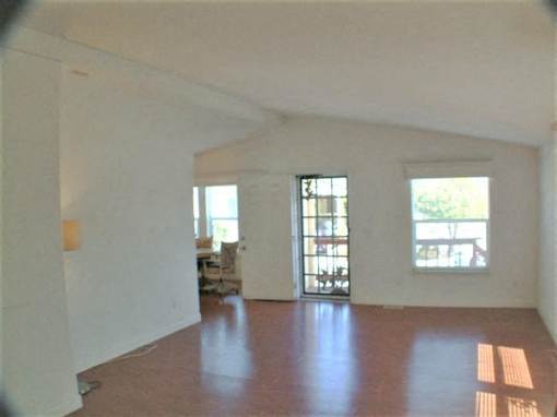an empty living room with white walls and wood floors