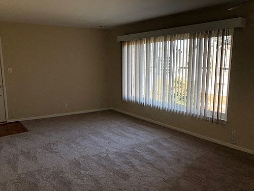 an empty living room with a large window