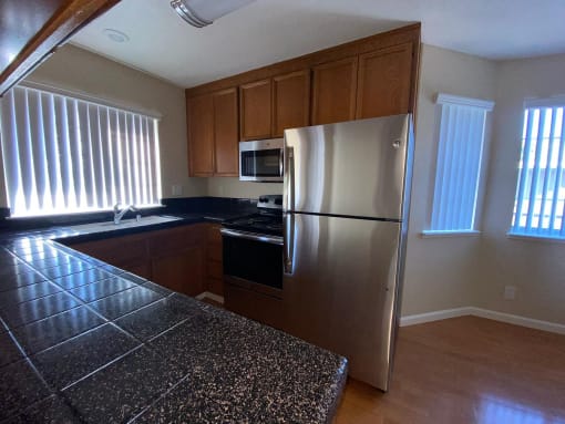 an empty kitchen with a stainless steel refrigerator
