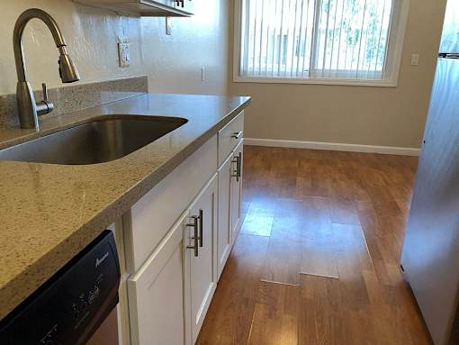 a kitchen with a sink and wooden floors
