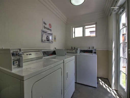 a laundry room with four washing machines in it