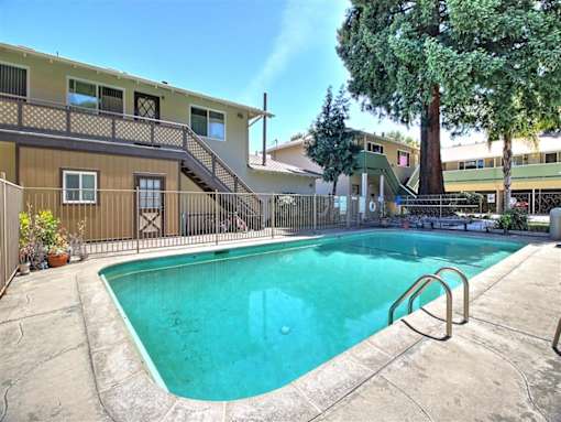 A small pool in a courtyard surrounded by a fence.