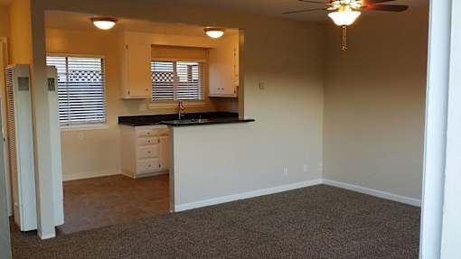 A kitchen area with a sink, countertop, and cabinets.