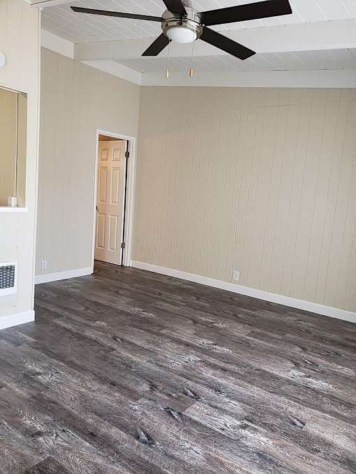 A room with a ceiling fan and a door.