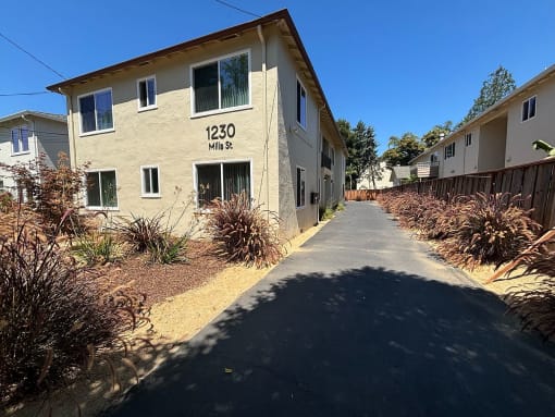 an apartment building with a sidewalk in front of it