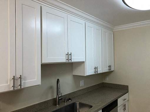 a kitchen with white cabinets and a sink