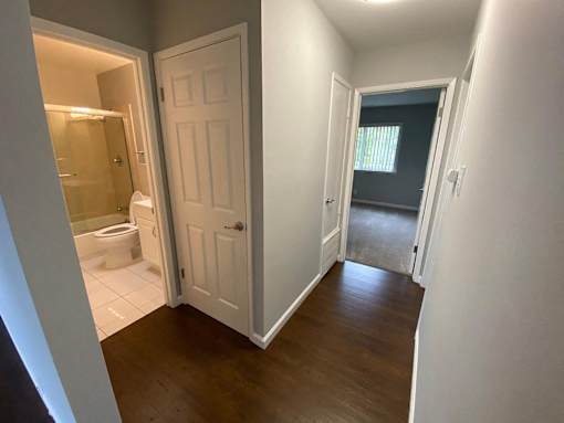 a view of a hallway with a door open to a bathroom