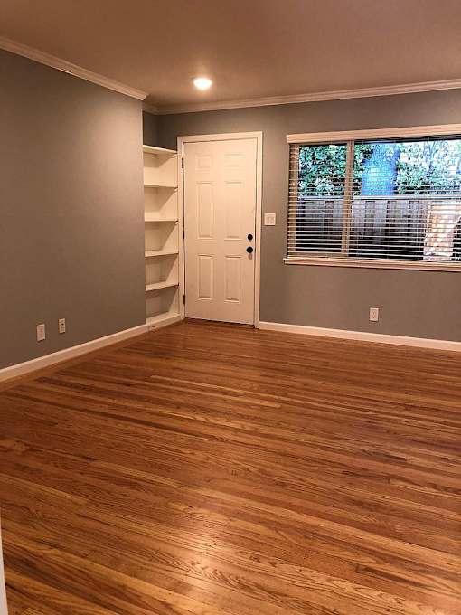 A room with wooden floors and a white door.