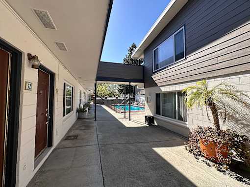 A sunny day at a residential area with a pool and a house numbered 52.