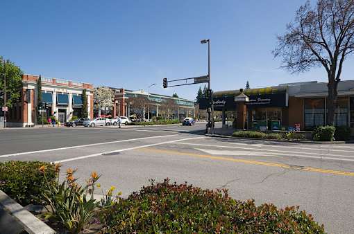 A street view with a traffic light and a car on the road.