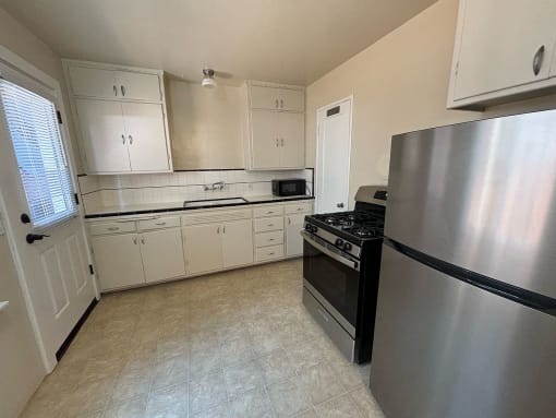 a kitchen with stainless steel appliances and white cabinets