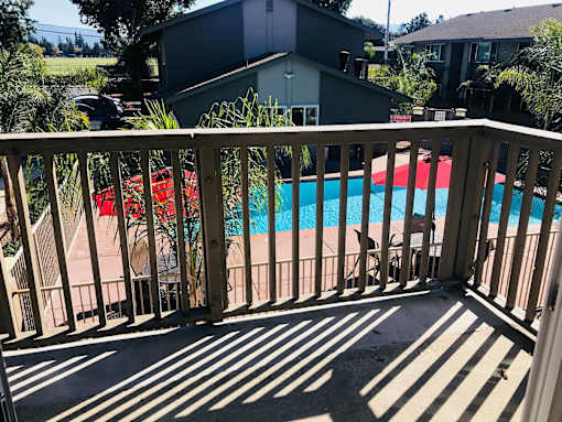 A pool is seen from a balcony.