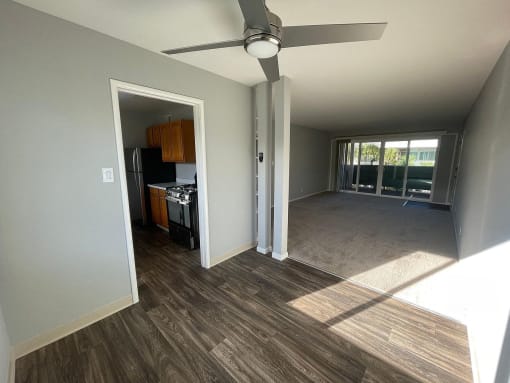a living room and kitchen with a ceiling fan
