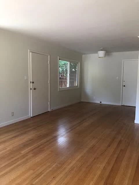 A room with wooden floors and white walls.