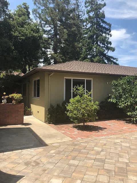 A small house with a brown roof and a brick wall.