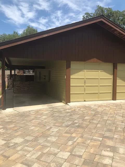 A garage with a brown roof and tan walls.
