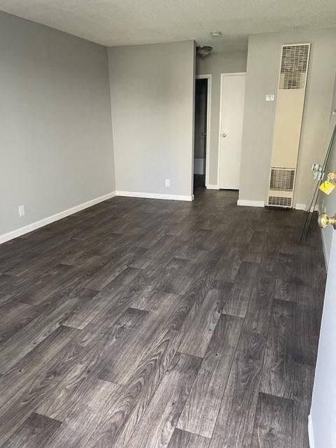 A room with a wood floor and a door on the right.
