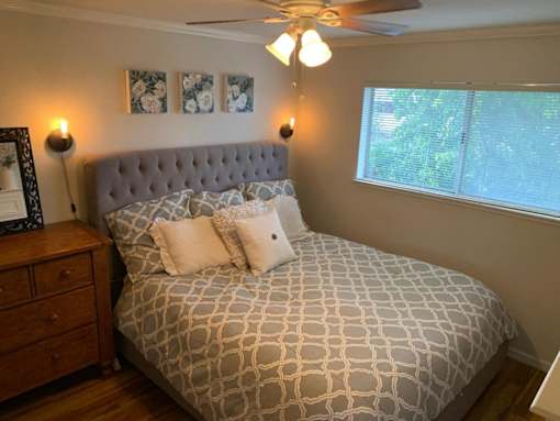 a bedroom with a bed and a ceiling fan and a window