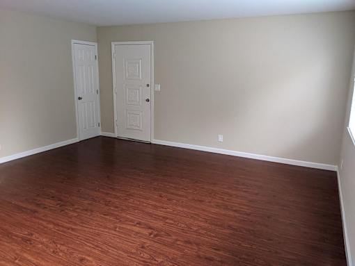 A room with two doors and wooden flooring.