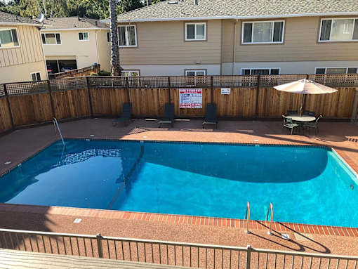 A small pool surrounded by a wooden fence.