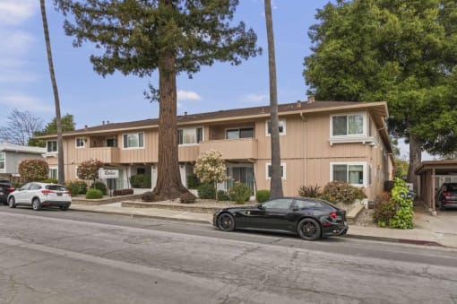 a black car parked in front of an apartment building