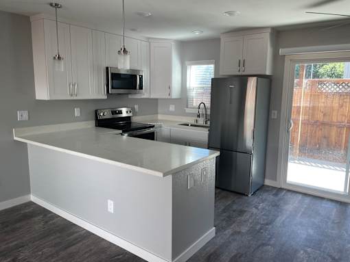 A kitchen with a white island and stainless steel appliances.