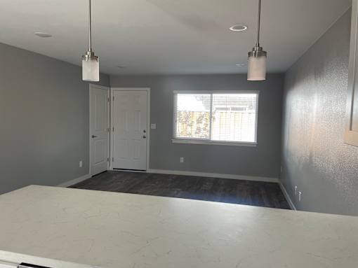 A room with a white table and two hanging lights.
