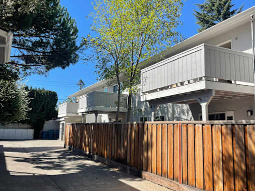 A modern house with a wooden fence in front.