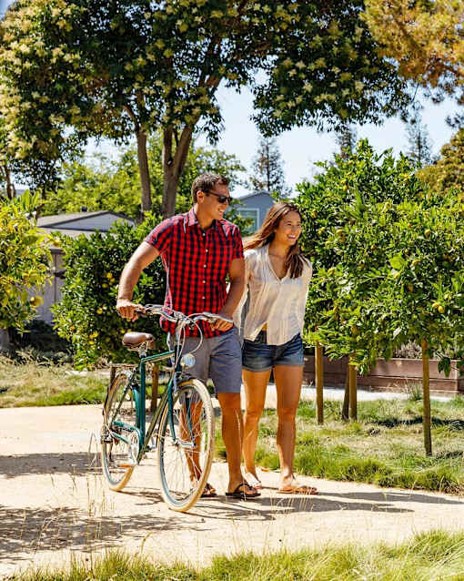 a man and a woman standing next to a bike