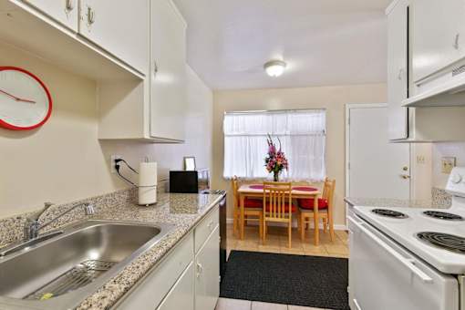 A kitchen with a table and chairs in the middle of it.