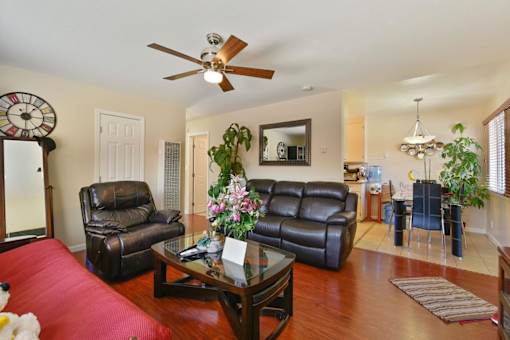 A living room with a red couch and a ceiling fan.
