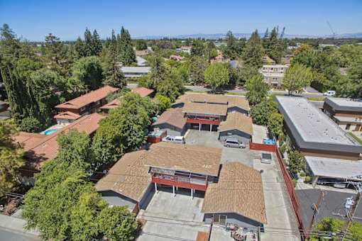 A large building with a red roof is surrounded by trees.
