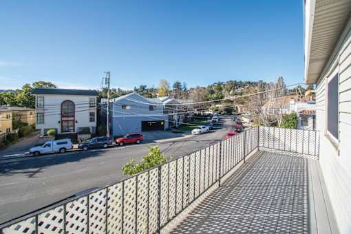 a view of a parking lot with a row of potted plants