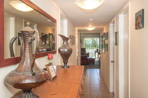 a view of a hallway with vases on a glass table
