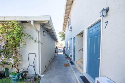 a white house with a blue door and a sidewalk