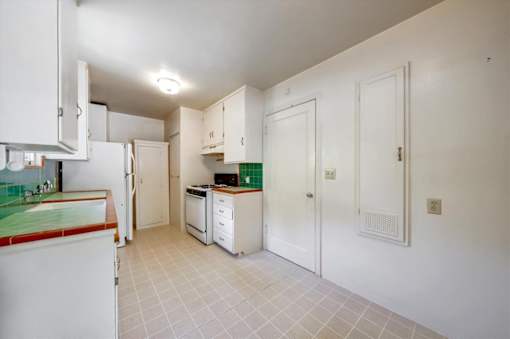 a kitchen with white cabinets and a stove and a refrigerator