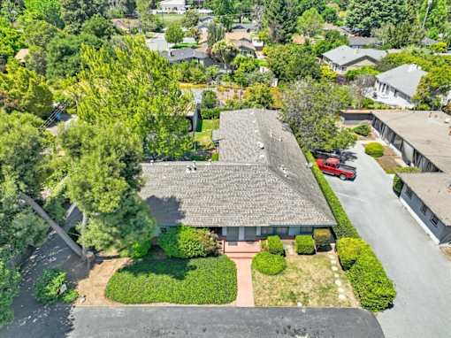 an aerial view of a building surrounded by trees and a parking lot