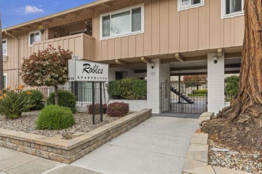 a sidewalk in front of a building with a ride apartments sign
