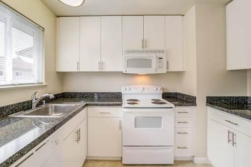 a kitchen with white appliances and white cabinets